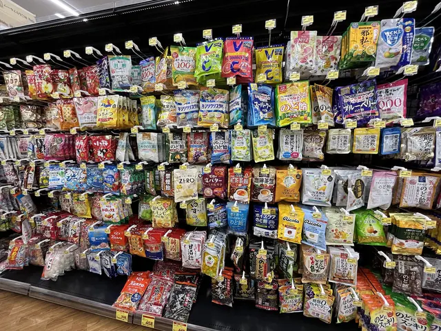 Rows of bagged sweets hanging on racks from top to bottom of a shop aisle