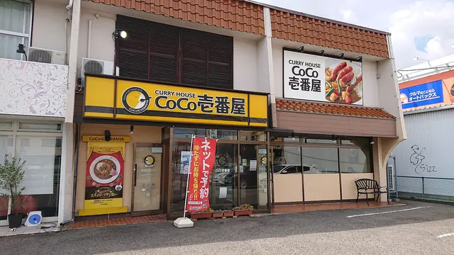 A CoCo Ichibanya curry restaurant with a yellow sign over the entrance