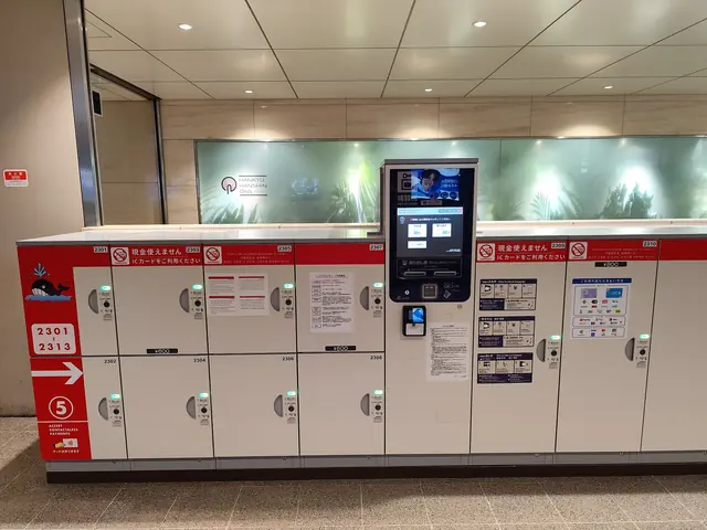 A bank of white lockers with a touch-screen payment terminal