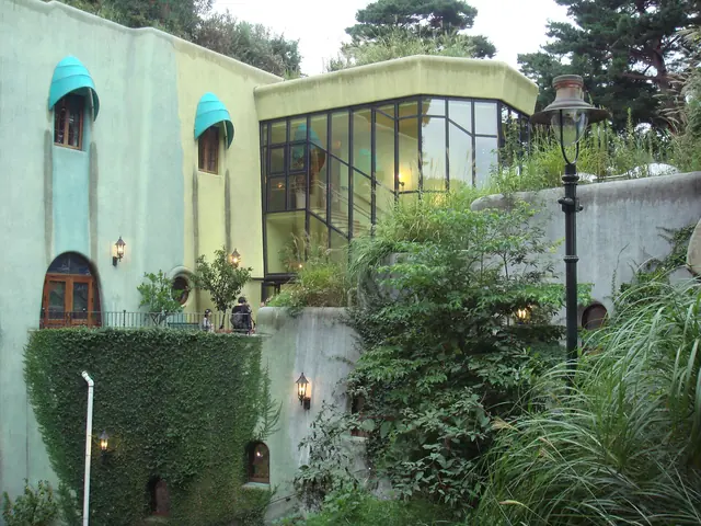 Pale green and yellow ivy-covered walls with turquoise awnings and a glass room