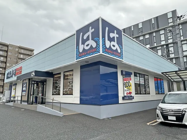 A white and navy Hama Sushi restaurant with large signs on the roof