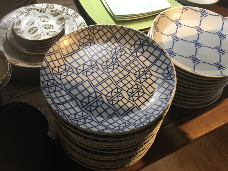 Stacks of plates with blue lattice and hexagon patterns on a shop table