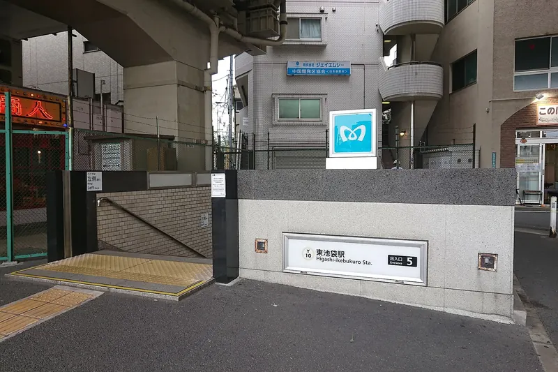Exit 5 of Higashi-Ikebukuro Station, a stairway entrance set under a raised expressway