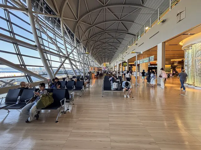 Photo: Fotointheworld (CC BY 4.0) A gate lounge under a curved steel-and-glass roof with passengers seated