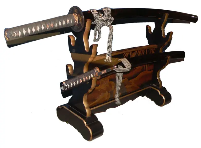 A long and a short Japanese sword in black lacquered scabbards resting on a horizontal lacquered sword stand