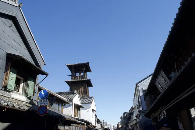 The wooden Toki no Kane bell tower above a street of dark merchant houses