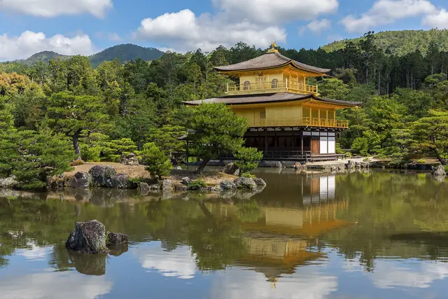 Photo: Basile Morin (CC BY-SA 4.0) The Golden Pavilion reflected in its pond among pine trees