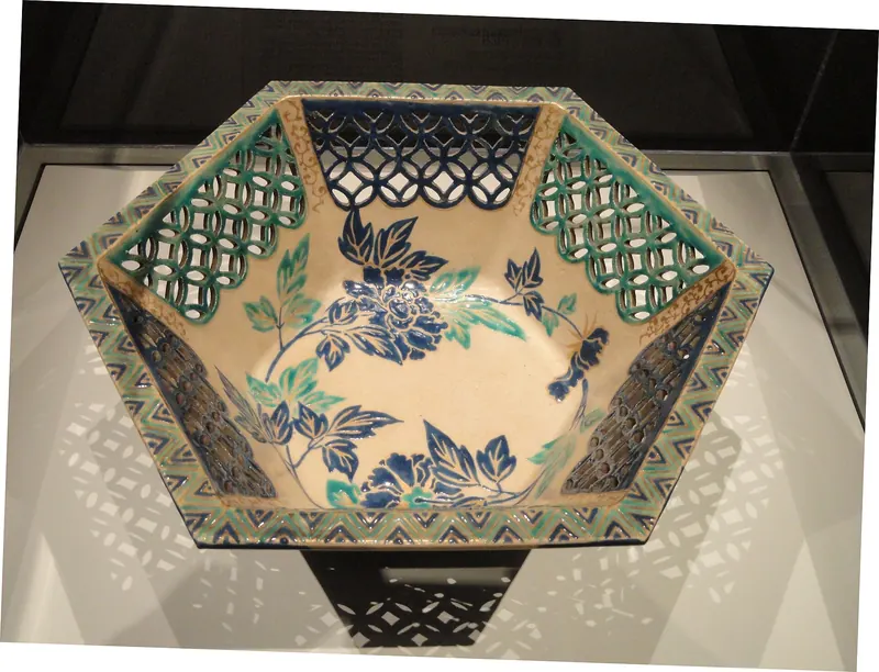 A six-sided bowl with openwork lattice sides and blue and green flowers painted inside