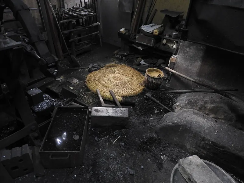 A dim blacksmith's workshop with tools on the walls and a round straw mat on the floor