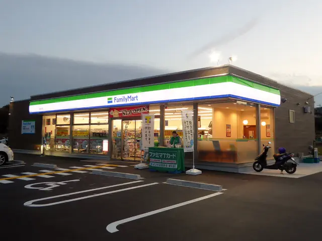 A FamilyMart convenience store lit at dusk with an empty car park and a parked scooter