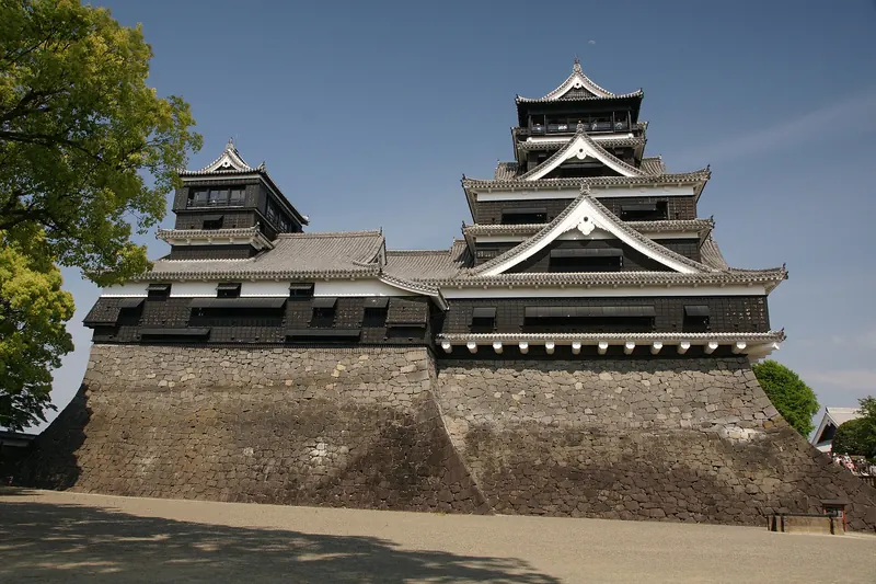 The black-and-white keep of Kumamoto Castle on stone walls