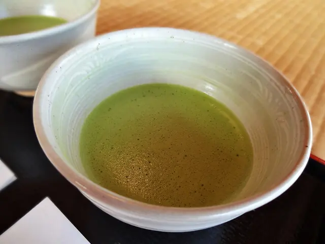 A close view of a bowl of frothy matcha on a tray