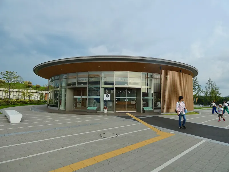 The round North Gate Information Center of Expo 2005 Aichi Commemorative Park, with a glass front and a wide paved plaza