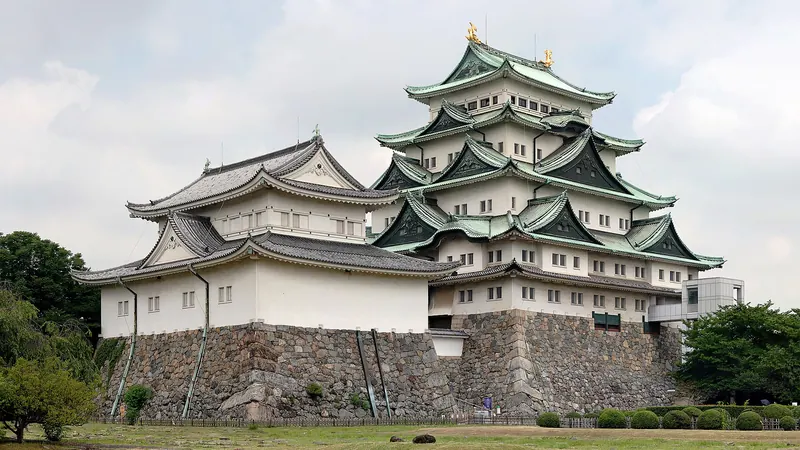 The white keep of Nagoya Castle with green roofs on a stone base