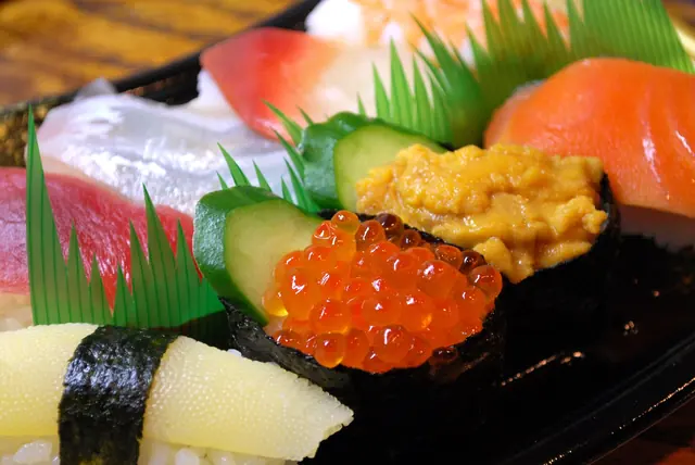A close-up of a pack of sushi with salmon roe and sea urchin gunkan, salmon, tuna, white fish and herring roe