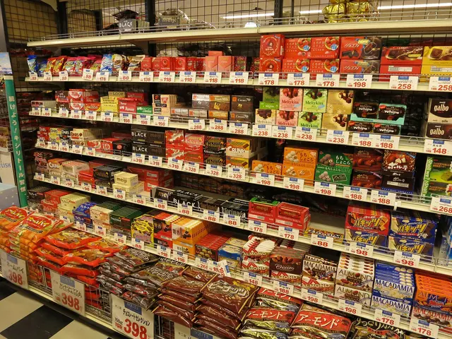 Shop shelves stacked with boxes and bags of chocolates and snacks, with yen price tags along each shelf edge