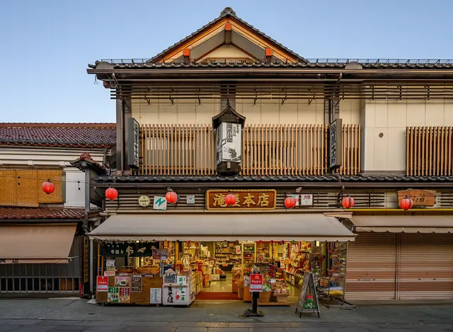 A traditional wooden shop with lanterns and goods under an awning