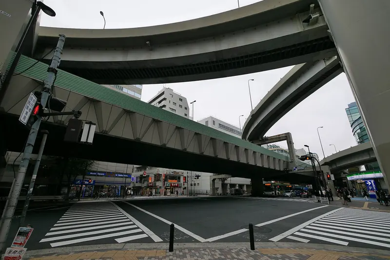 Zebra crossings at a wide junction under the curving ramps of the Shuto Expressway in Higashi-Ikebukuro