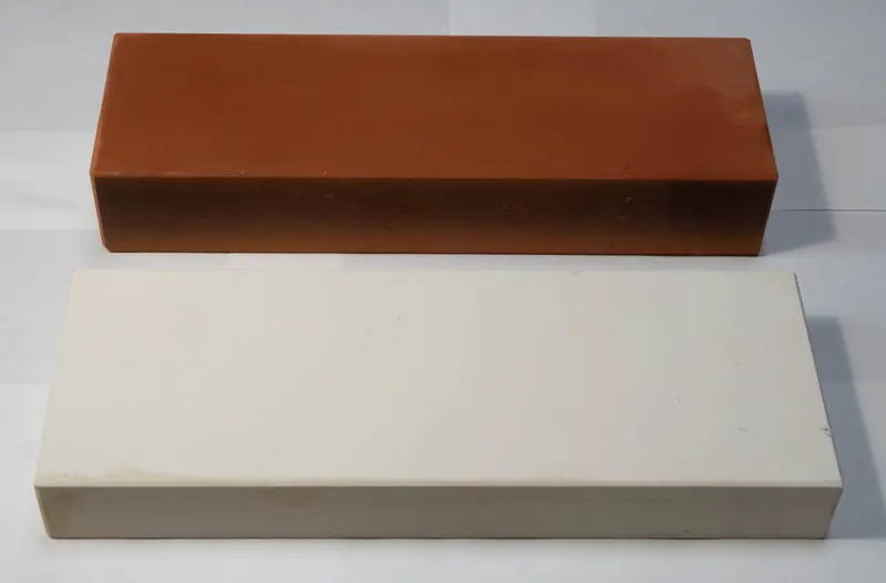 Two rectangular sharpening stones, one reddish brown and one white